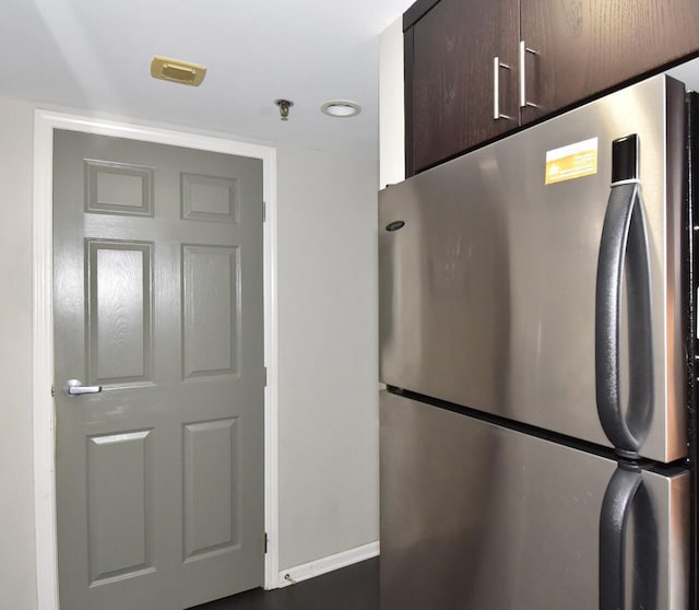 270 E Highland Ave Unit 644, Milwaukee, WI 53202 - detailed view of freestanding refrigerator, dark brown cabinets, a pendent fire sprinkler, and baseboards