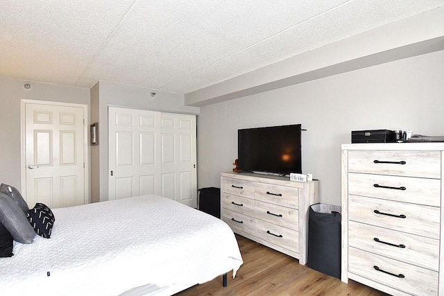 270 E Highland Ave Unit 644, Milwaukee, WI 53202 - bedroom featuring wood finished floors, a textured ceiling, and a closet