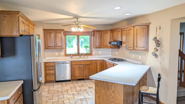 N8292 Deadwood Point Rd, Fond Du Lac, WI 54937 - kitchen with stainless steel appliances, a peninsula, a sink, under cabinet range hood, and a ceiling fan