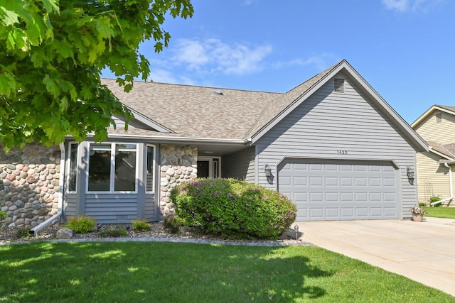 1420 Hidden Fields Dr, West Bend, WI 53095 - ranch-style house with an attached garage, stone siding, concrete driveway, roof with shingles, and a front lawn