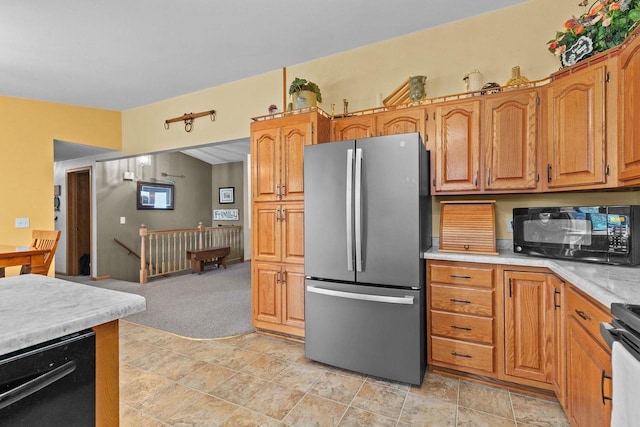 557 Center St, Berlin, WI 54923 - kitchen with black appliances, light countertops, light carpet, brown cabinetry, and light stone finish flooring