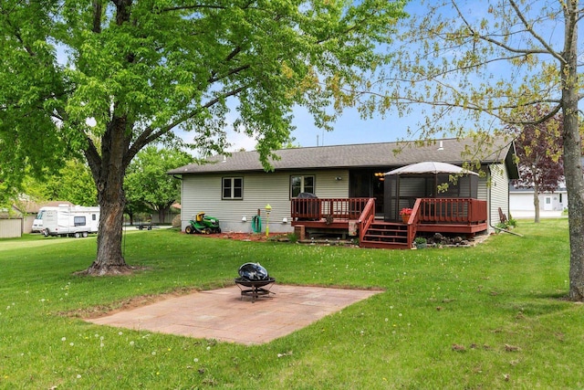 557 Center St, Berlin, WI 54923 - back of property featuring a patio area, a deck, a lawn, a fire pit, and a shingled roof