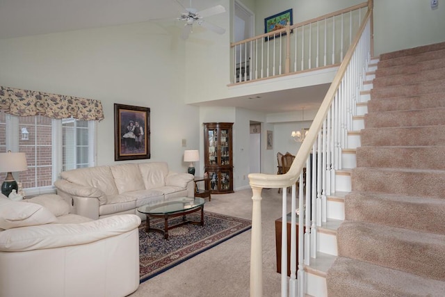 8707 Westlake Dr, Greendale, WI 53129 - living area featuring stairway, carpet floors, a ceiling fan, a high ceiling, and a chandelier