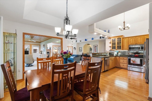 119 Summit Ct, Columbus, WI 53925 - dining room featuring a chandelier, light wood-style flooring, and arched walkways