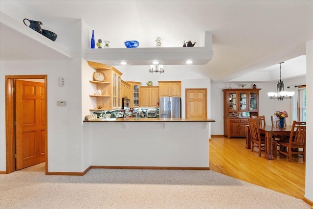 119 Summit Ct, Columbus, WI 53925 - kitchen with appliances with stainless steel finishes, a chandelier, glass insert cabinets, light carpet, and a peninsula