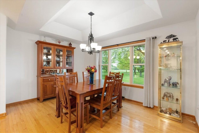 119 Summit Ct, Columbus, WI 53925 - dining room with a tray ceiling, light wood-type flooring, baseboards, and a chandelier
