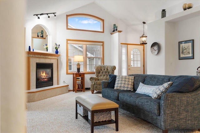 119 Summit Ct, Columbus, WI 53925 - carpeted living area featuring lofted ceiling, a tiled fireplace, and track lighting