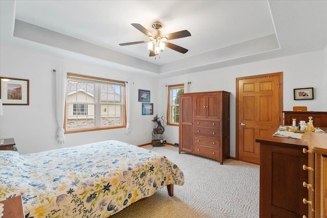 119 Summit Ct, Columbus, WI 53925 - bedroom featuring a tray ceiling, light carpet, and a ceiling fan