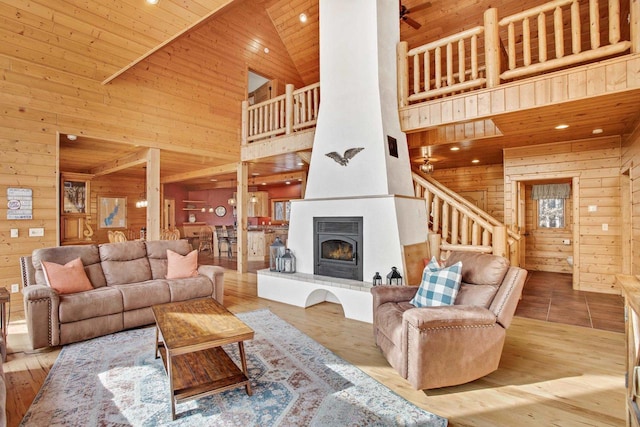 W5271 Southview Dr, Necedah, WI 54646 - living room featuring high vaulted ceiling, wooden walls, wooden ceiling, stairway, and a fireplace