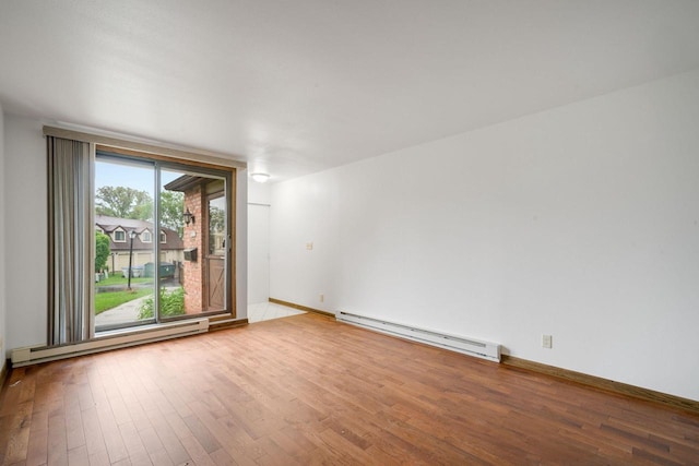 7233 W Wabash Ave, Milwaukee, WI 53223 - spare room featuring a baseboard radiator, hardwood / wood-style flooring, and baseboards