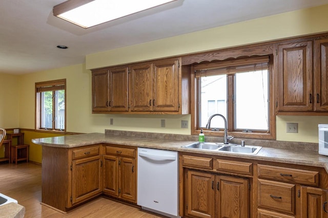 1074 Pendleton Rd, Neenah, WI 54956 - kitchen with white appliances, a sink, a peninsula, light wood-style floors, and brown cabinetry