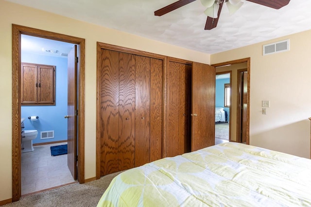 1074 Pendleton Rd, Neenah, WI 54956 - carpeted bedroom featuring two closets, ensuite bath, baseboards, and ceiling fan