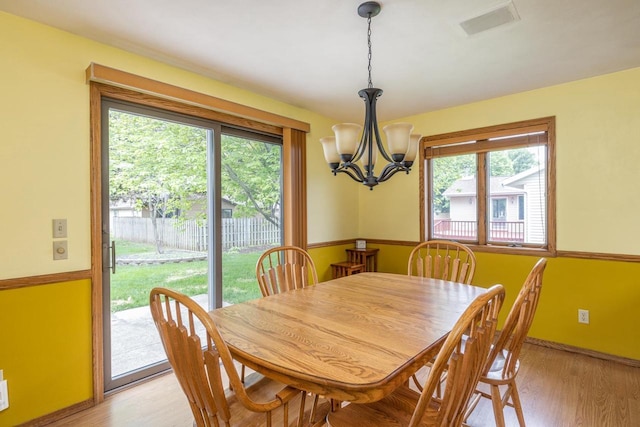 1074 Pendleton Rd, Neenah, WI 54956 - dining room featuring a chandelier, healthy amount of natural light, light wood-type flooring, and baseboards