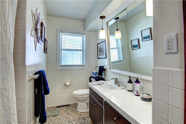 709 E Fillmore Ave, Eau Claire, WI 54701 - bathroom with vanity, toilet, tile walls, and wainscoting