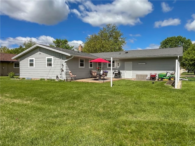 709 E Fillmore Ave, Eau Claire, WI 54701 - back of property with a patio, a lawn, and a chimney