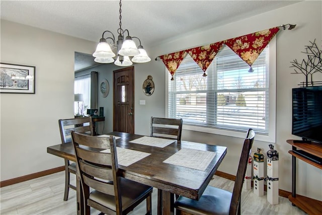 709 E Fillmore Ave, Eau Claire, WI 54701 - dining room with a chandelier, light wood-style flooring, and baseboards