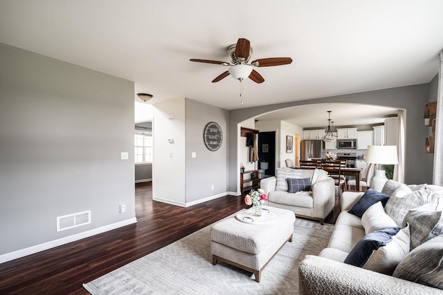 6544 Biscayne Ave, Mount Pleasant, WI 53406 - living area with arched walkways, dark wood-type flooring, baseboards, and a ceiling fan