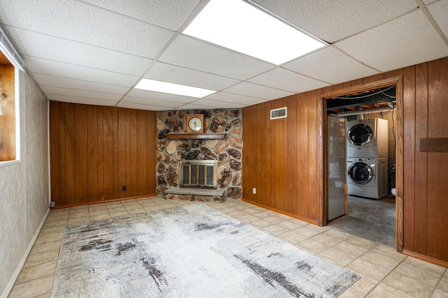 3324 96th St, Sturtevant, WI 53177 - unfurnished living room featuring stacked washer and clothes dryer, wooden walls, a fireplace, a paneled ceiling, and baseboards