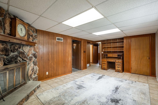3324 96th St, Sturtevant, WI 53177 - unfurnished living room with a paneled ceiling, wood walls, built in shelves, a fireplace, and baseboards