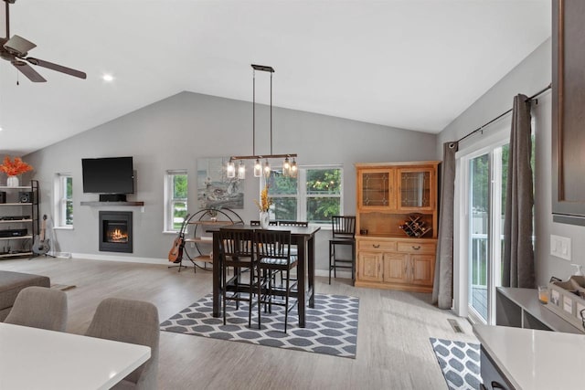 1930 Waterview Blvd, Plover, WI 54467 - dining room with vaulted ceiling, light wood finished floors, a lit fireplace, ceiling fan, and baseboards