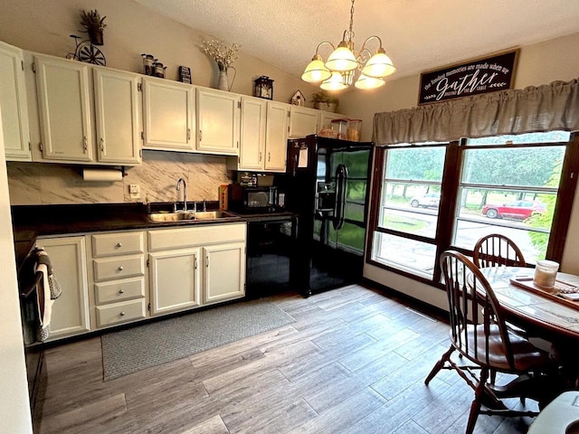 2621 Golf Course Rd, Wisconsin Rapids, WI 54494 - kitchen with black appliances, a sink, dark countertops, white cabinets, and a textured ceiling