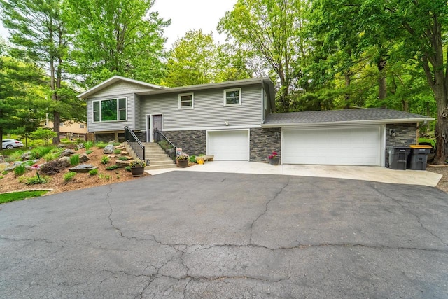 503 N 43rd Ave, Wausau, WI 54401 - split foyer home featuring driveway, stone siding, and an attached garage