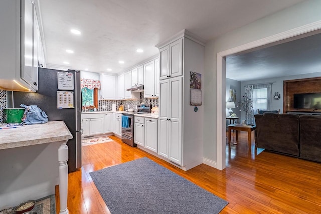 503 N 43rd Ave, Wausau, WI 54401 - kitchen with appliances with stainless steel finishes, light countertops, decorative backsplash, light wood-style flooring, and white cabinetry