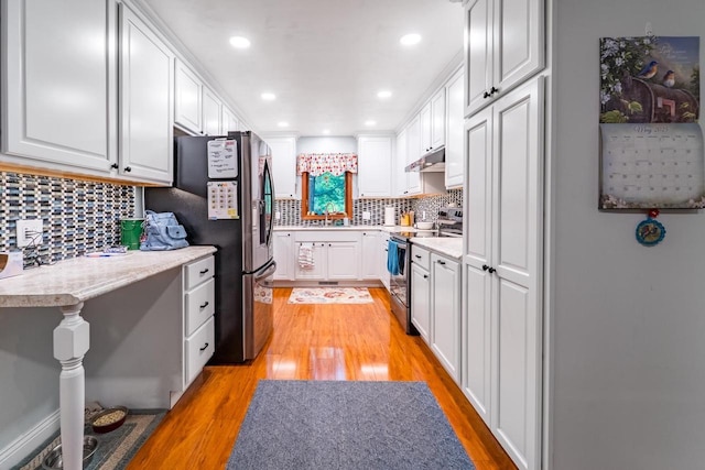 503 N 43rd Ave, Wausau, WI 54401 - kitchen featuring appliances with stainless steel finishes, under cabinet range hood, light wood finished floors, white cabinets, and recessed lighting