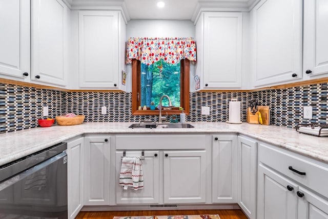 503 N 43rd Ave, Wausau, WI 54401 - kitchen featuring stainless steel dishwasher, a sink, white cabinets, decorative backsplash, and light countertops