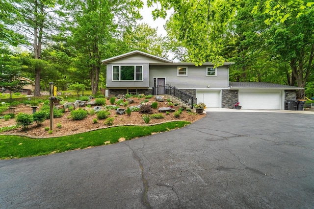 503 N 43rd Ave, Wausau, WI 54401 - raised ranch featuring stone siding, driveway, and a garage