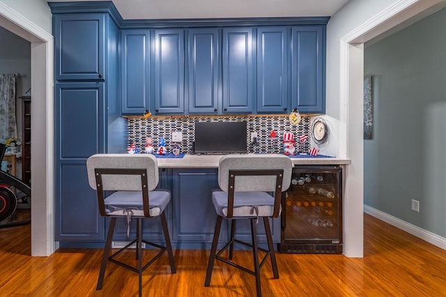 503 N 43rd Ave, Wausau, WI 54401 - kitchen featuring blue cabinets, beverage cooler, and tasteful backsplash