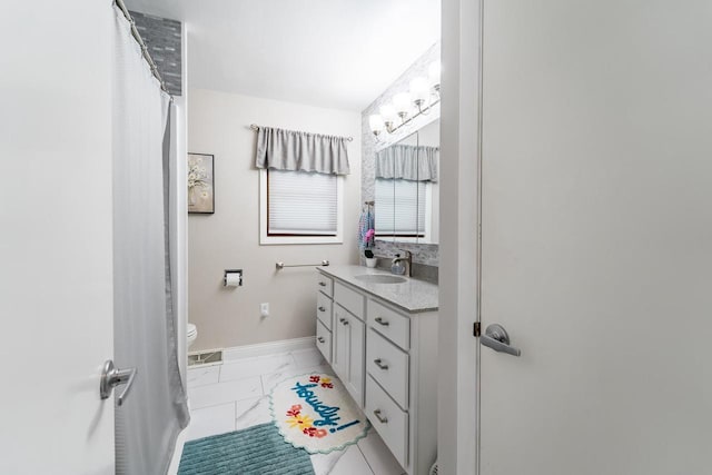 503 N 43rd Ave, Wausau, WI 54401 - bathroom featuring marble finish flooring, vanity, baseboards, and toilet