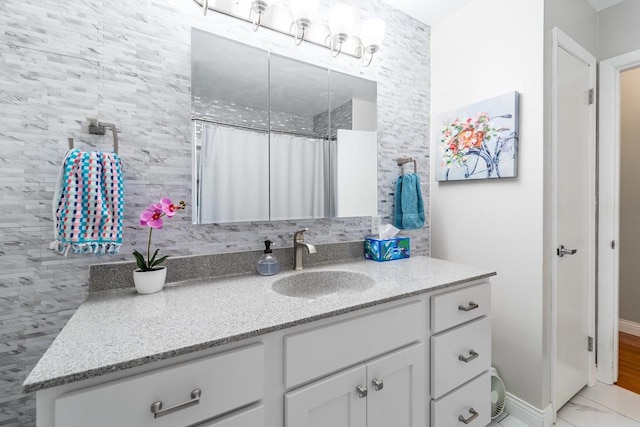 503 N 43rd Ave, Wausau, WI 54401 - bathroom featuring vanity, marble look tiles, and baseboards