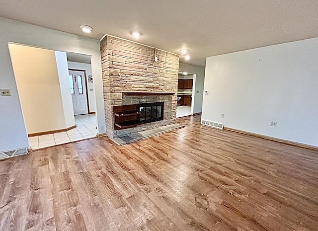 5404 N Bethmaur Ln, Milwaukee, WI 53209 - unfurnished living room featuring wood finished floors, baseboards, and a stone fireplace