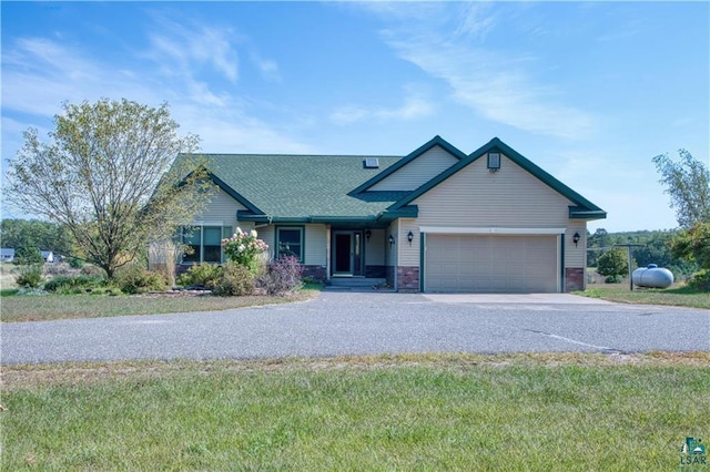 9018 N Anderson Rd, Hayward, WI 54843 - view of front facade featuring concrete driveway, an attached garage, a shingled roof, and a front lawn