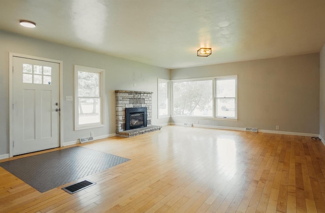 85 N Reserve Ave, Fond Du Lac, WI 54935 - unfurnished living room with healthy amount of natural light, a stone fireplace, wood-type flooring, and baseboards