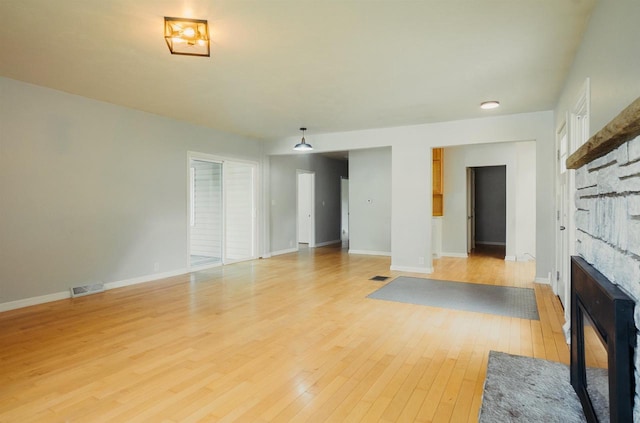 85 N Reserve Ave, Fond Du Lac, WI 54935 - unfurnished living room featuring a glass covered fireplace, light wood-style floors, and baseboards
