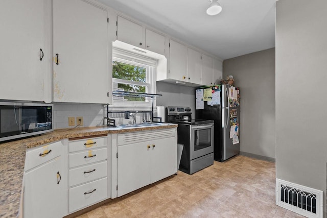 768 Reed St, Neenah, WI 54956 - kitchen with stainless steel appliances, decorative backsplash, white cabinets, and light countertops