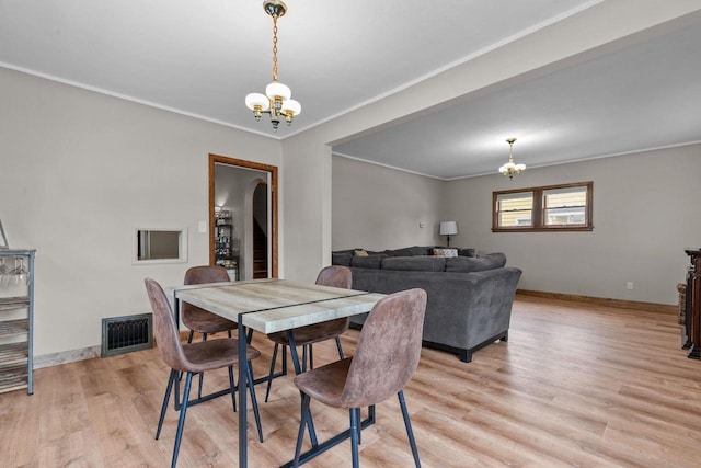 768 Reed St, Neenah, WI 54956 - dining area with a chandelier, light wood finished floors, crown molding, and baseboards