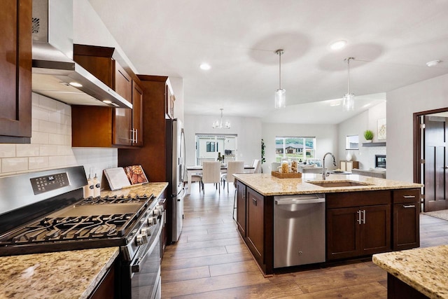 5829 Prairie Cloud Ct, Waunakee, WI 53597 - kitchen featuring appliances with stainless steel finishes, wall chimney range hood, dark wood-type flooring, open floor plan, and decorative backsplash