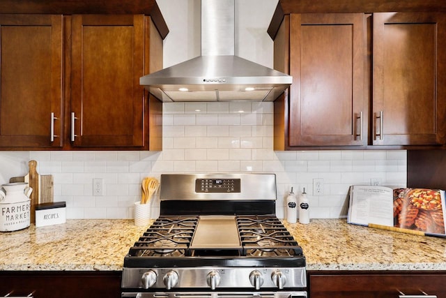 5829 Prairie Cloud Ct, Waunakee, WI 53597 - kitchen featuring wall chimney exhaust hood, stainless steel gas range, decorative backsplash, and light stone countertops