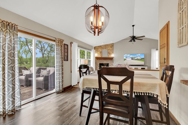 6905 Jamestown Ct, West Bend, WI 53090 - dining area featuring a chandelier, a brick fireplace, vaulted ceiling, light wood finished floors, and ceiling fan