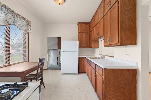 314 Summit St, Pulaski, WI 54162 - kitchen with freestanding refrigerator, a sink, brown cabinets, and light floors