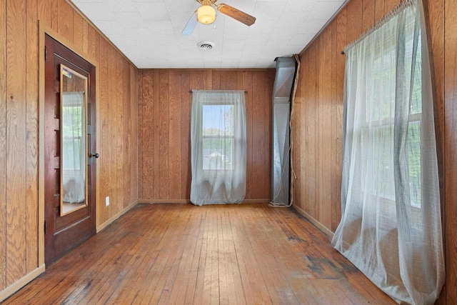 314 Summit St, Pulaski, WI 54162 - spare room featuring wood-type flooring, wood walls, ceiling fan, and baseboards