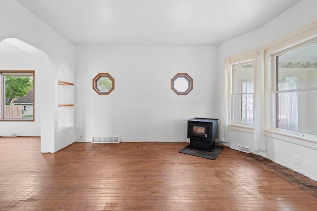 314 Summit St, Pulaski, WI 54162 - unfurnished living room with hardwood / wood-style floors, a wood stove, and arched walkways