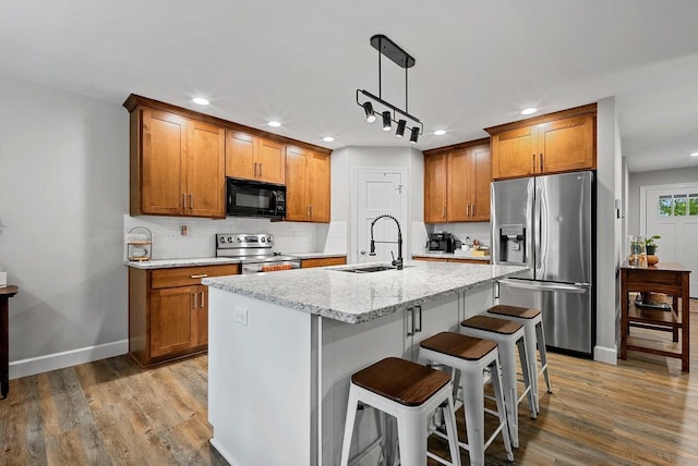 1302 Daytona Ln, Little Chute, WI 54140 - kitchen featuring stainless steel appliances, a sink, brown cabinets, recessed lighting, and backsplash