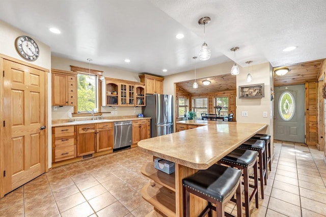 127 Flora St, Pulaski, WI 54162 - kitchen featuring appliances with stainless steel finishes, a sink, open shelves, a kitchen bar, and recessed lighting