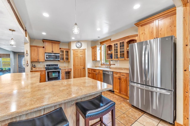 127 Flora St, Pulaski, WI 54162 - kitchen with appliances with stainless steel finishes, a sink, recessed lighting, a kitchen breakfast bar, and glass insert cabinets