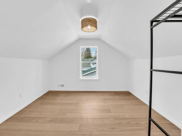4208 Locust St, Delavan, WI 53115 - additional living space featuring light wood finished floors, vaulted ceiling, and baseboards