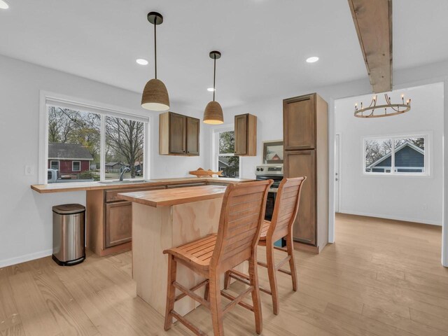 4208 Locust St, Delavan, WI 53115 - kitchen featuring butcher block counters, a sink, light wood finished floors, a chandelier, and healthy amount of natural light